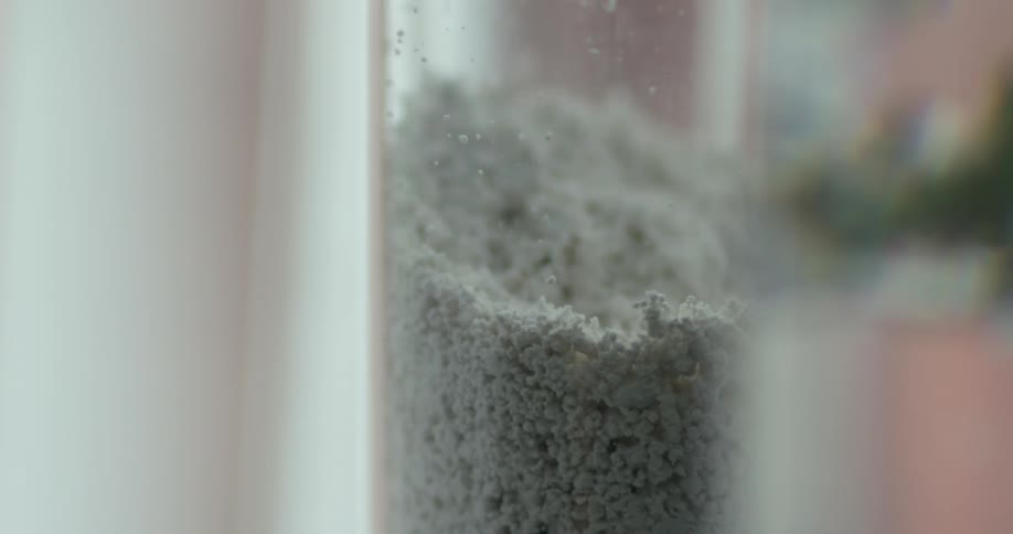 Pale gray particles fill clear glass