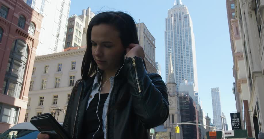 A woman is standing in a downtown city