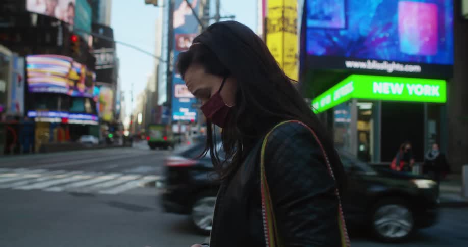 A woman is checking her phone in the intersection