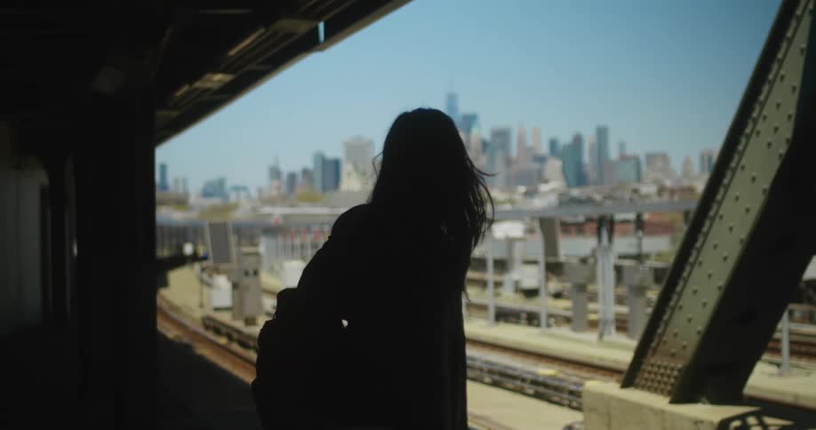 A woman walks on the platform to wait for a train