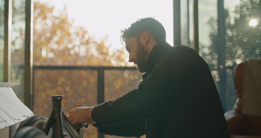 A man is putting a bike together indoors