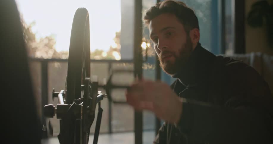 A man rotating his bicycle tires while making repairs