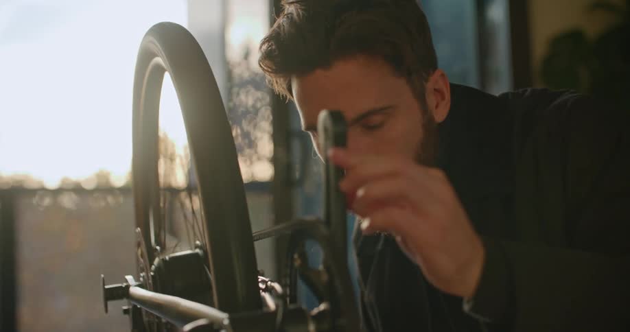 A man rotating his bike tires while making repairs