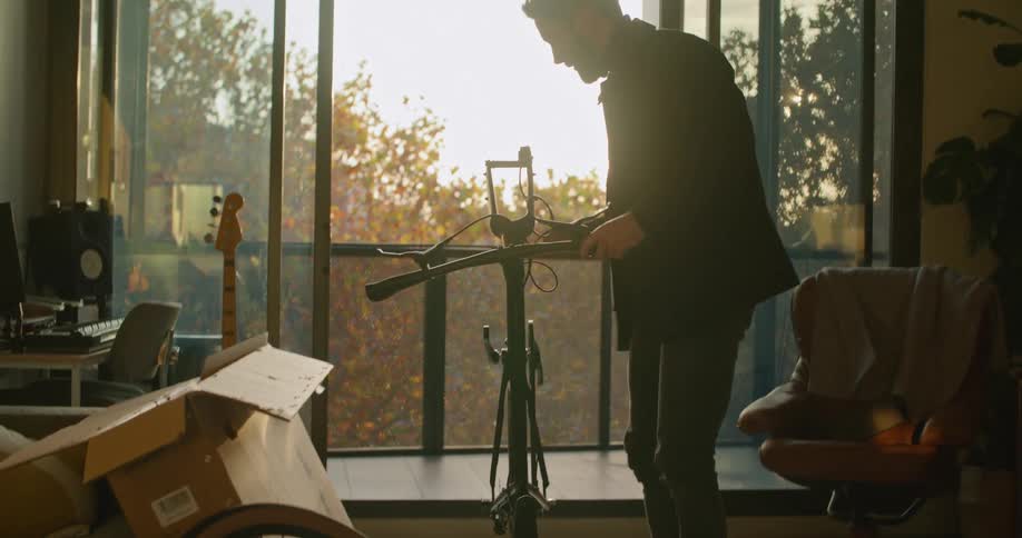 A man is frustrated while trying to put a bicycle together