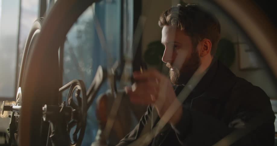 A male caucasian peddling a bike with his hands in a room