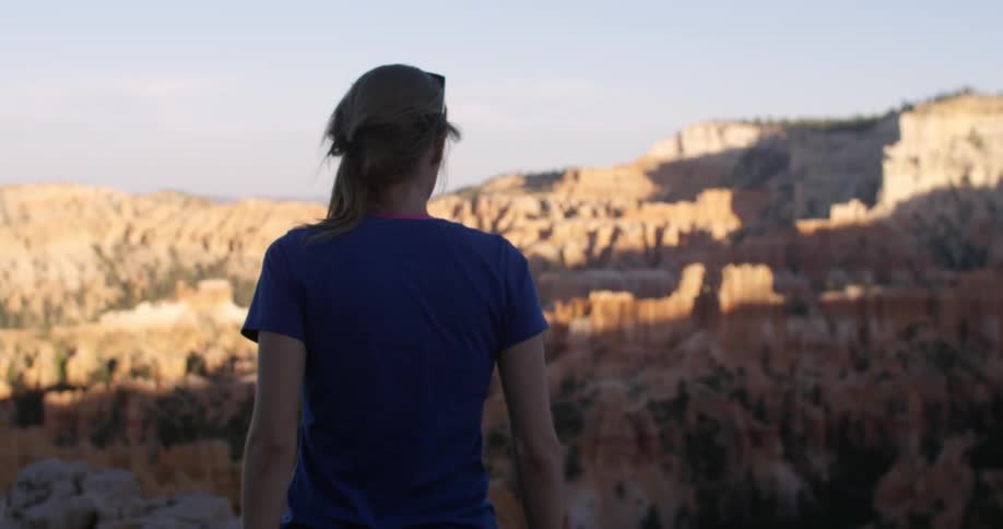A woman walks through a rocky landscape