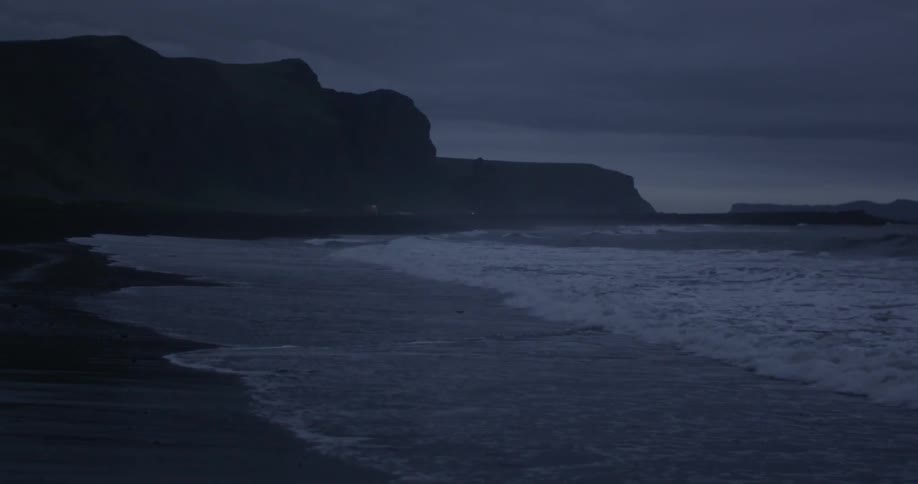 Waves coming ashore on a dark cloudy night
