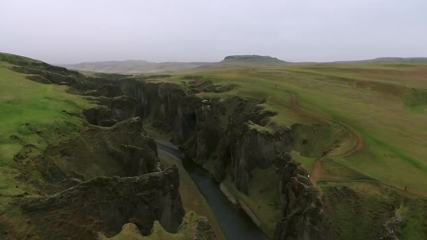 Water runs between two cliffs covered with grass