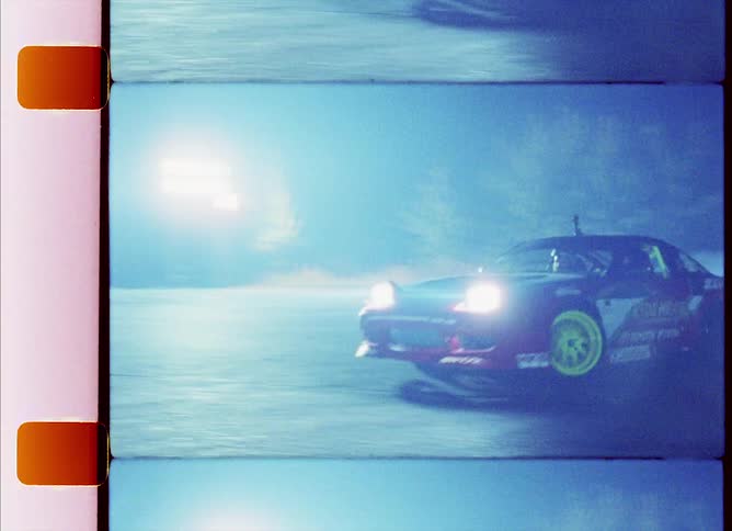 A racing car is drifting on a road during night time