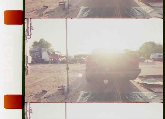 A car is driving away from a repair garage on a sunny day