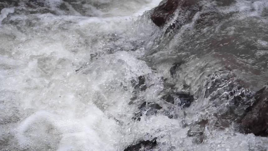 Clear water flowing over the rocks on a river at daytime