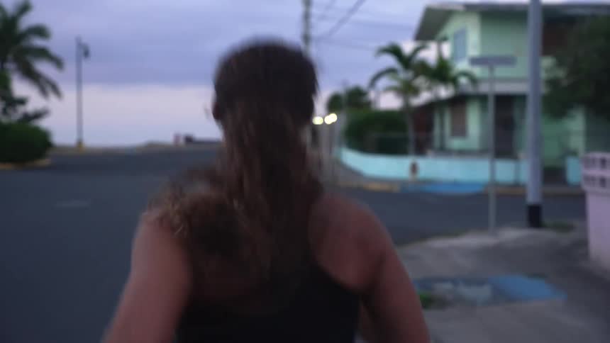 A woman running down a tropical street