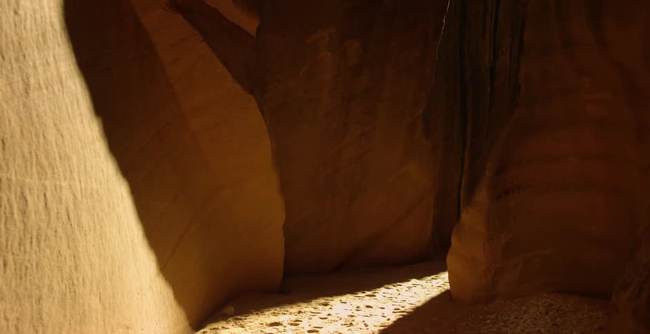 Sunset sunlight enters the narrow corridor on a canyon in the desert