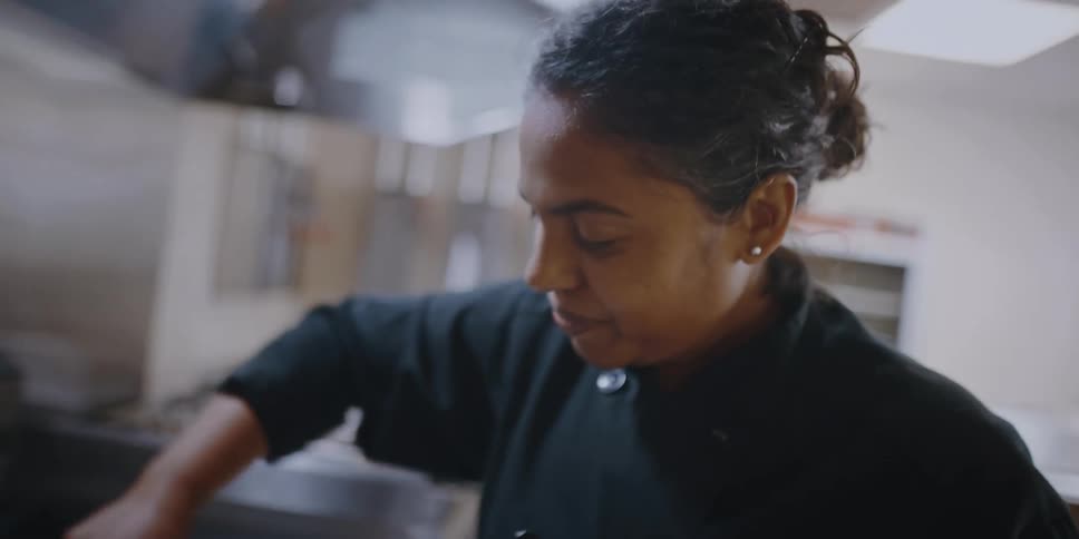 A woman stirring food in a kitchen