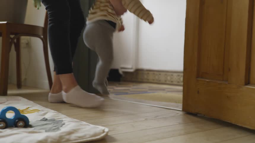 A mother picking up her son crawling around
