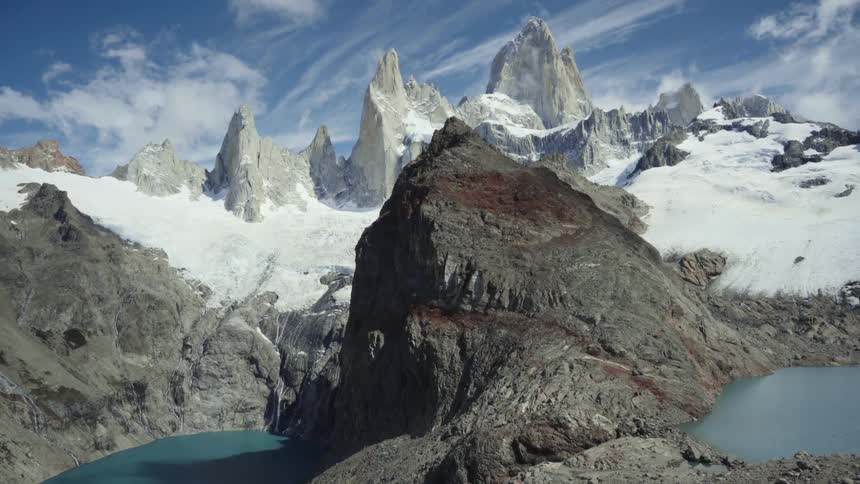 Snow covered mountains with peaks high in a cloudy sky