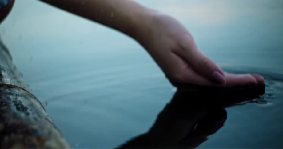 Hand scooping water on the lake