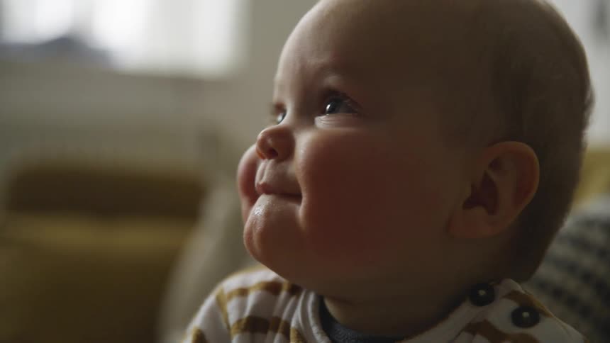 Baby waves phone around and looks around