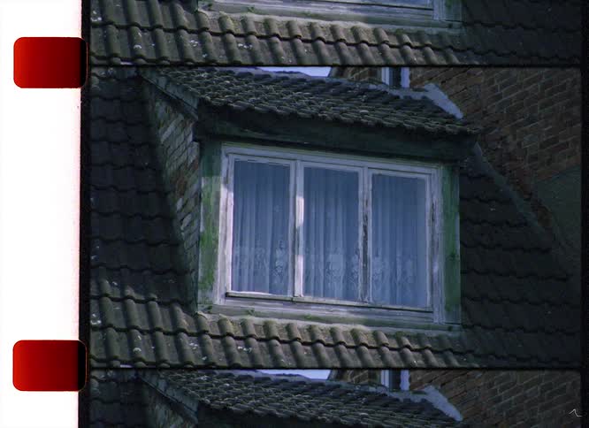 Window sits in roof line of brick walled building