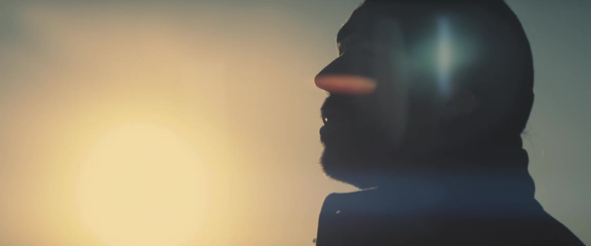 The sun shines down on a man outside