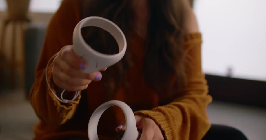 A woman playing with a virtual reality headset and controllers