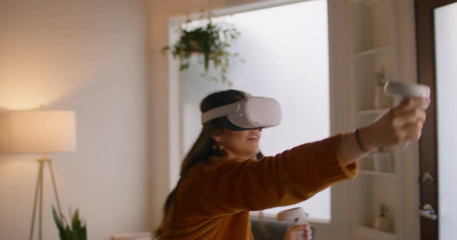 Woman plays a video game using virtual reality goggles at home