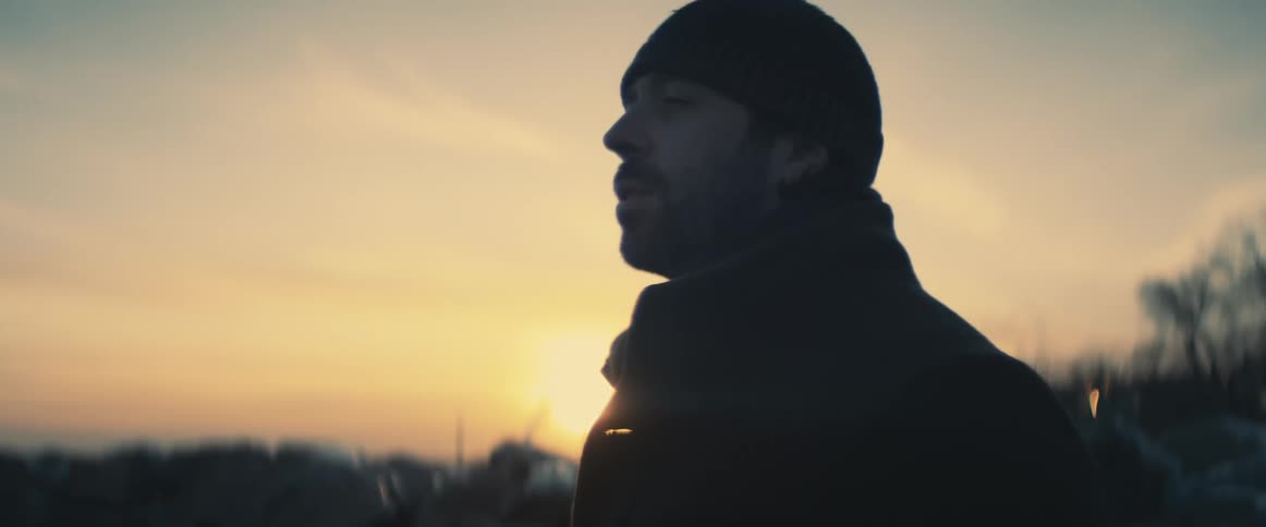 A man takes a deep breath outside
