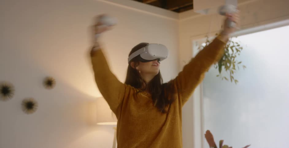 A teenage girl plays a virtual reality game at home