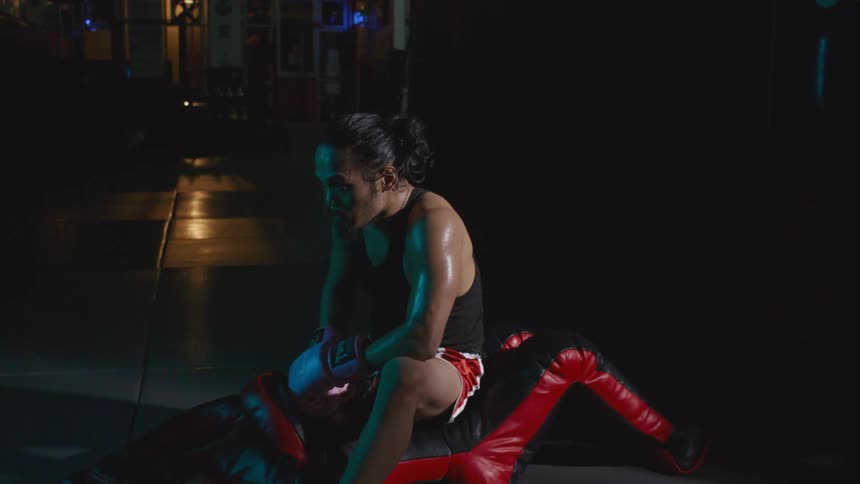A man sitting on a bench with boxing gloves