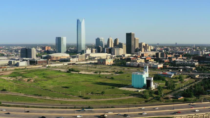 Traffic flows along streets near city downtown under clear blue sky