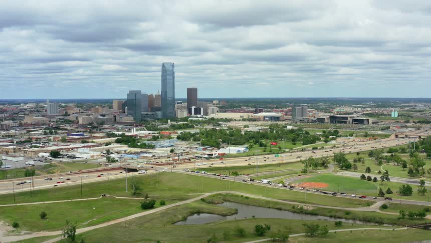 Cars are driving on a highway near a city in spring