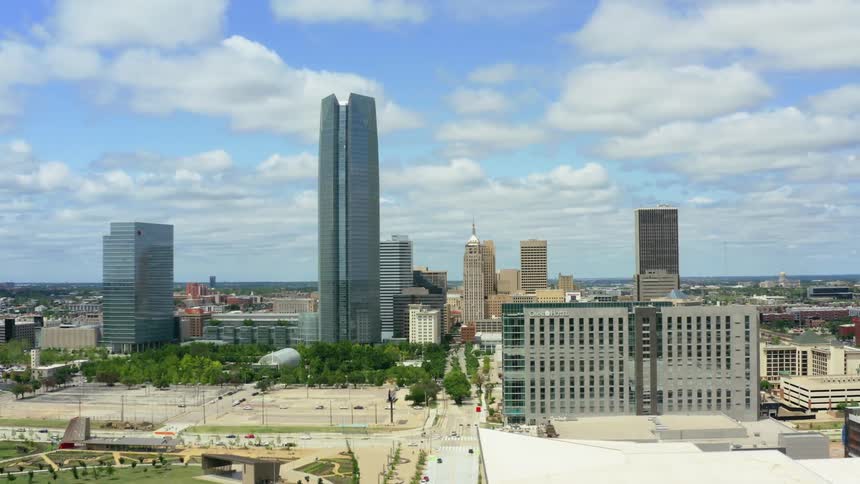 An aerial view of a downtown skyline with high rise office buildings and cars driving on streets