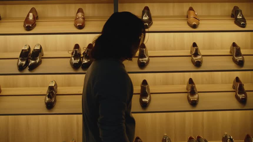 A man is walking past looking at all the shoes
