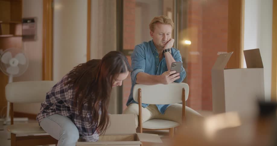 Two people are moving and looking through boxes