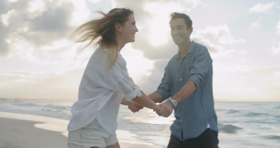 A man and woman dance on the beach