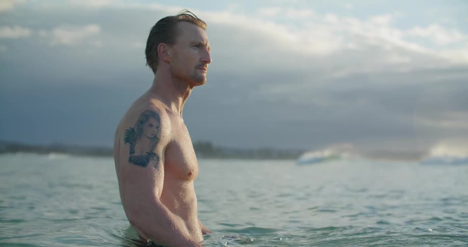 A man standing in the ocean in the middle of the day