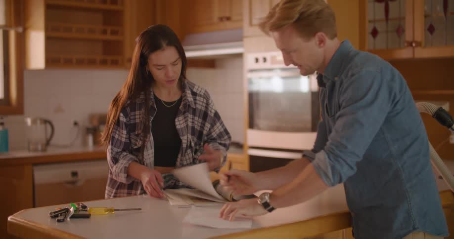 Young couple taking notes on the kitchen table at home