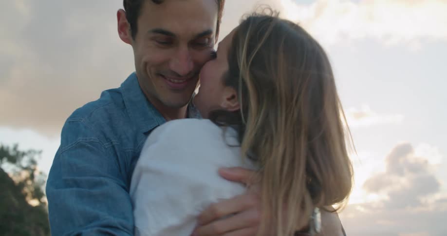 Husband and wife are hugging eachother outdoors at dusk
