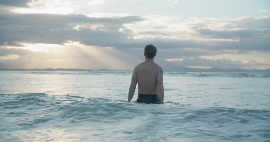 A man standing in the ocean thinking