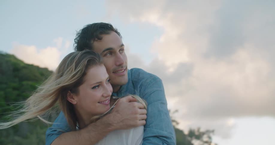 A man and woman embracing outside on a breezy day