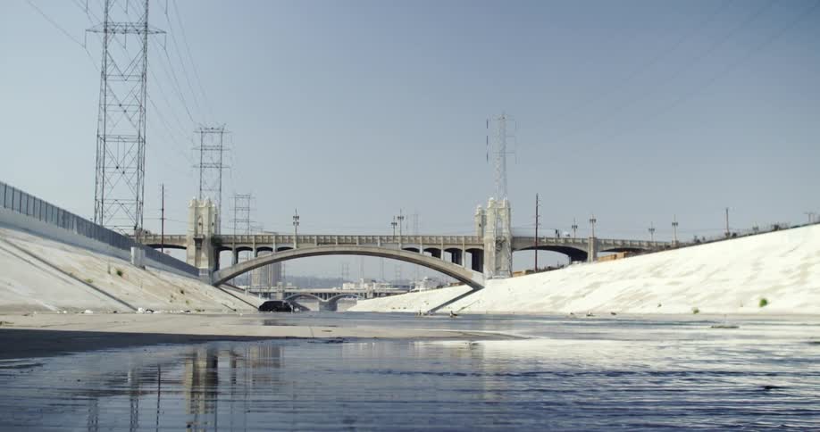 Cars drive across a bridge over a canal