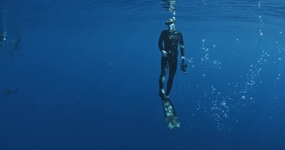 A scuba diver swims towards the surface