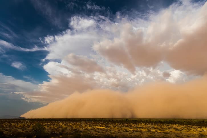 A dust strom rolling through a field