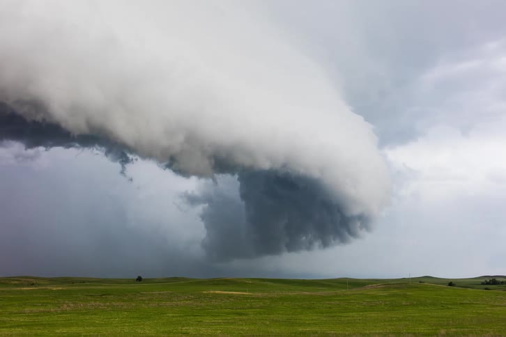 A large storm cloud flows over the field