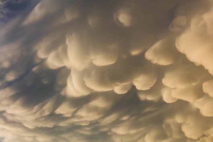 Sunlight shines through dense fluffy clouds