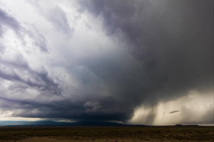 Storm clouds moving across a field as lightning flashes
