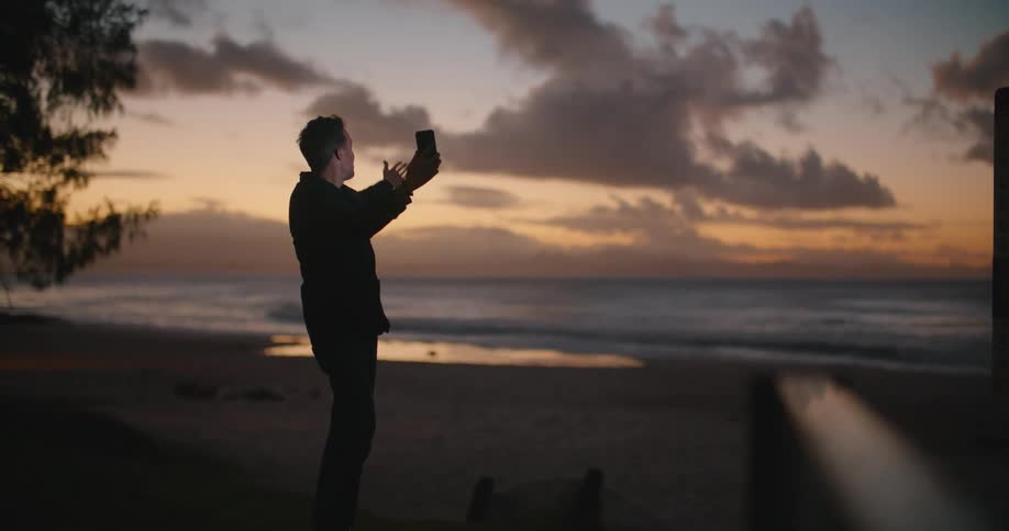 A man talking on a phone at a beach