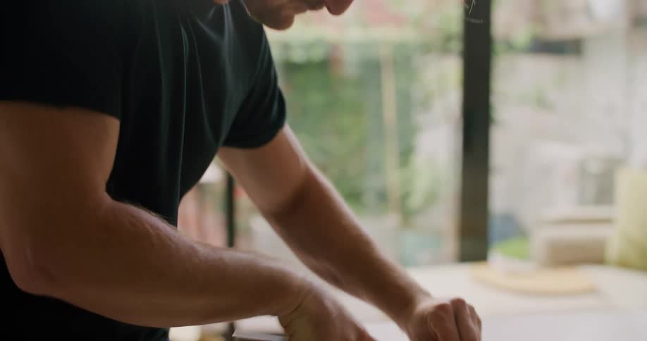 A man is dicing food on a cutting board