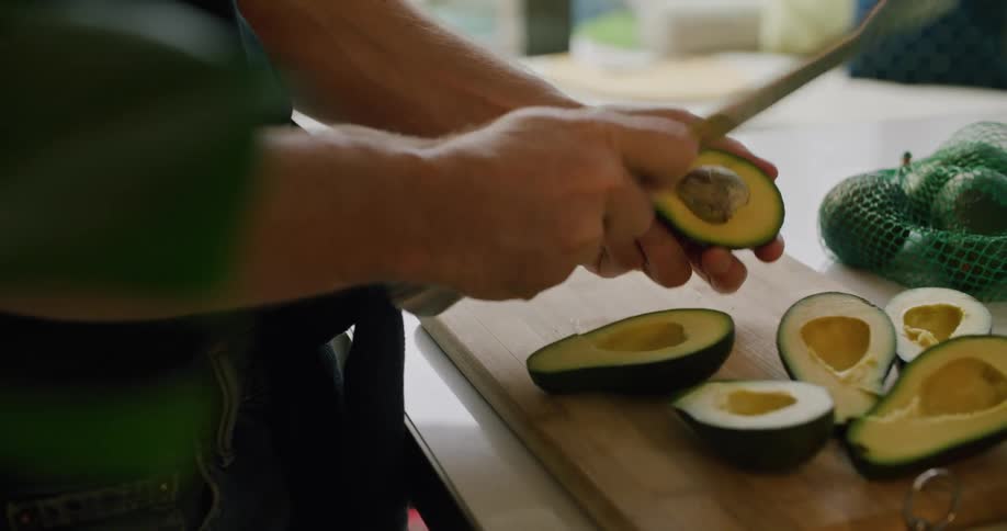 A man is cutting avocados