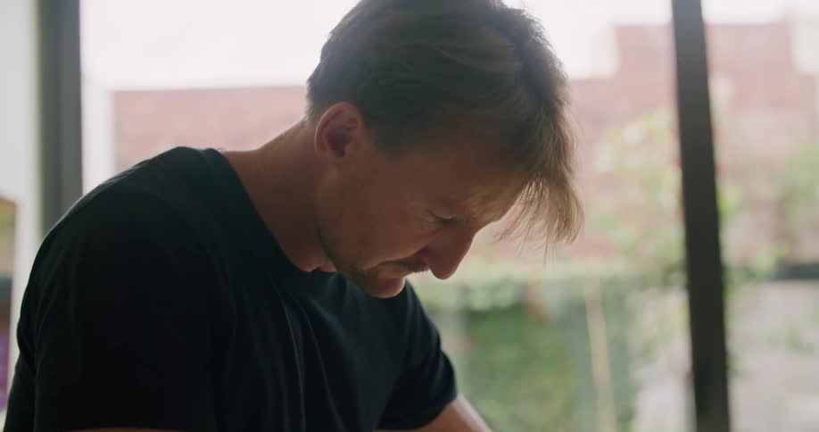 Man chopping vegetables with a sharp knife over a board on the kitchen at home